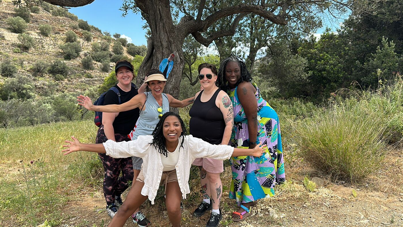 The group posing playfully under an olive tree