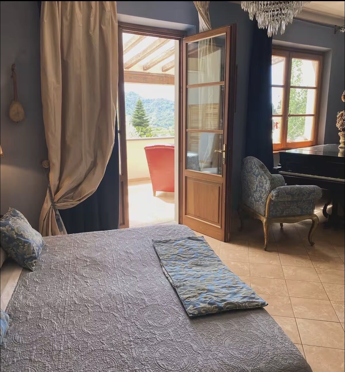 Elegant villa bedroom with balcony doors open to mountain views